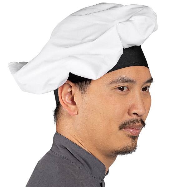 A man wearing a Uncommon Chef white chef hat.