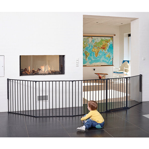 A baby sitting on the floor in front of a black L.A. Baby room divider.