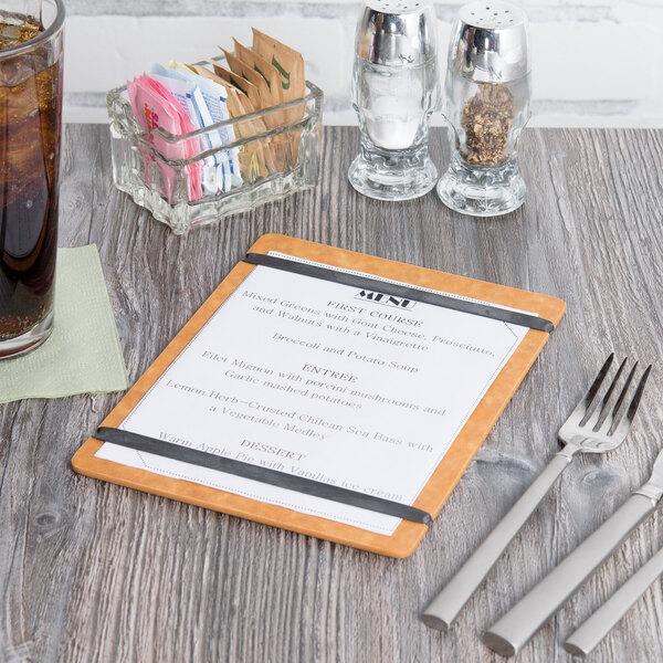 A Cal-Mil natural wood menu board with flex bands on a wood table with a fork and knife.