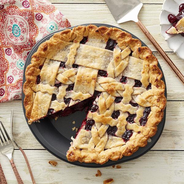 A Wilton deep dish pie on a table with a slice missing.