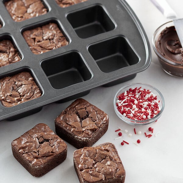 A Wilton bite-size brownie pan with brownies topped with chocolate spread and sprinkles.