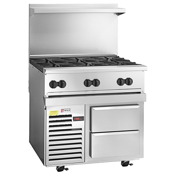 A large stainless steel Wolf commercial range with 6 burners and 2 refrigerated drawers.