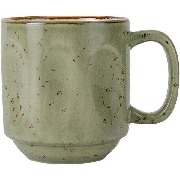 A green Tuxton China Yukon mug with brown specks and a handle.