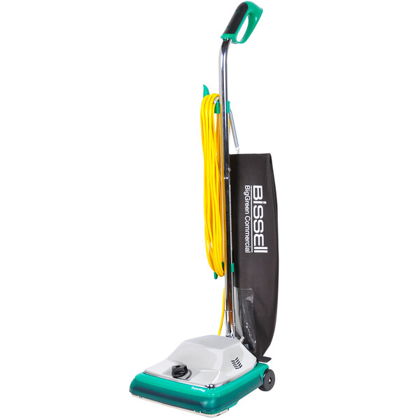A Bissell Commercial bagged upright vacuum cleaner with a green handle and bag.