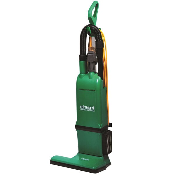 A close-up of a green and black Bissell Commercial dual motor bagged upright vacuum cleaner.
