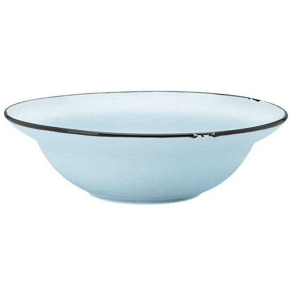A close-up of a Luzerne blue porcelain entree bowl with a black rim.