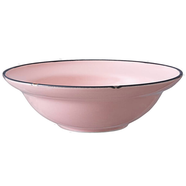 A white porcelain pasta bowl with a pink interior and black rim.