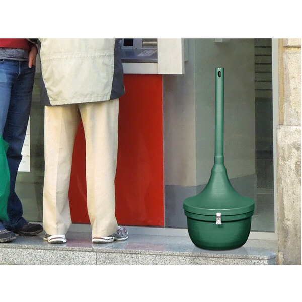 A person's leg with a green bag using an Ex-Cell Kaiser Hunter Green cigarette receptacle.