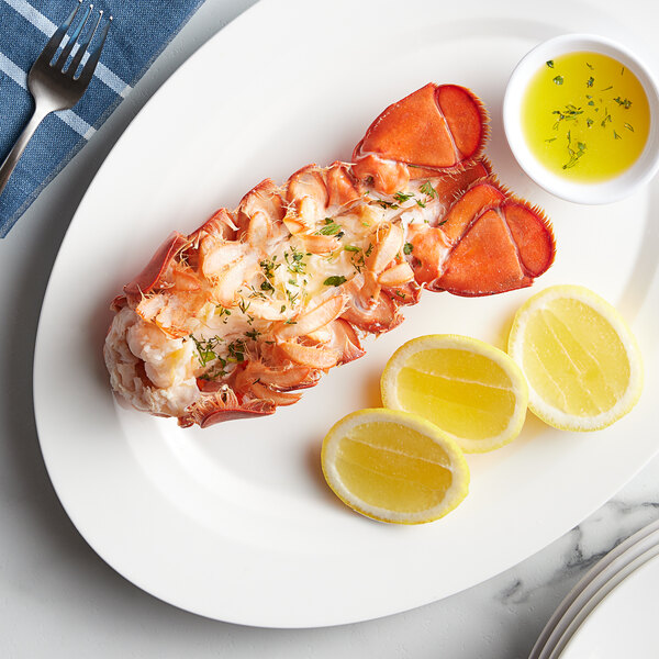 A Boston Lobster Company 8-10 oz. lobster tail on a plate with lemon slices and butter.