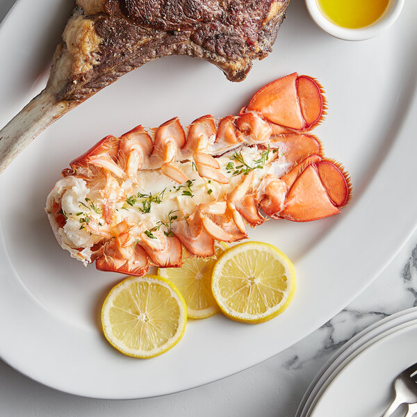A plate of food with a Boston Lobster Company lobster tail and lemon slices.