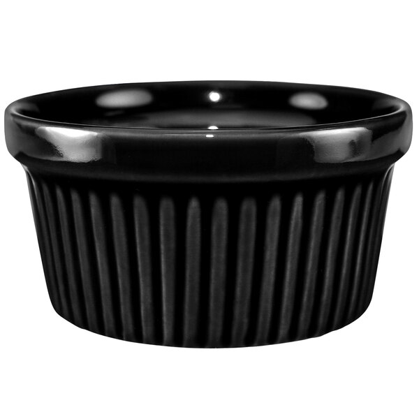 A black fluted stoneware ramekin with a rim.