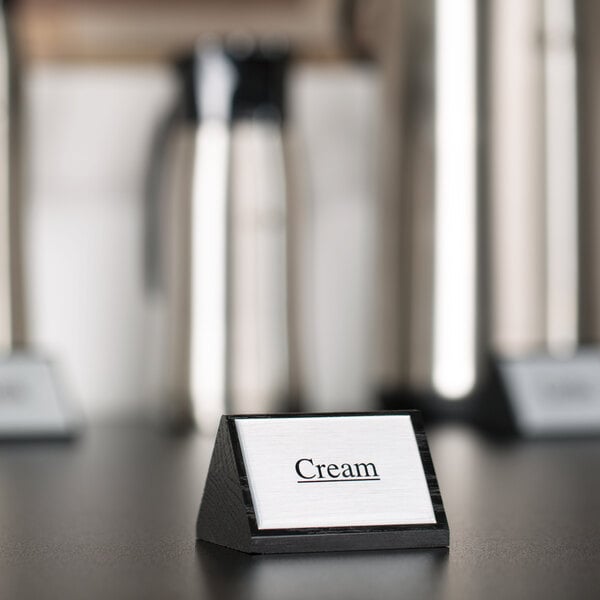 An American Metalcraft wood sign that says "Cream" on a hotel buffet counter.