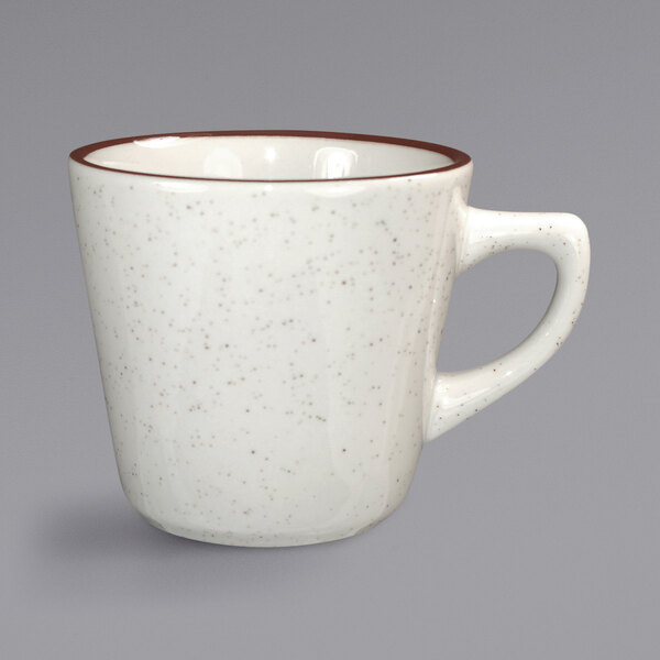 An International Tableware ivory stoneware tall cup with a brown speckled rim and handle.