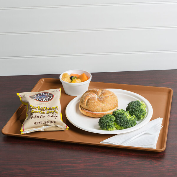 A Cambro dietary tray with a sandwich, broccoli, and a bag of chips on it.