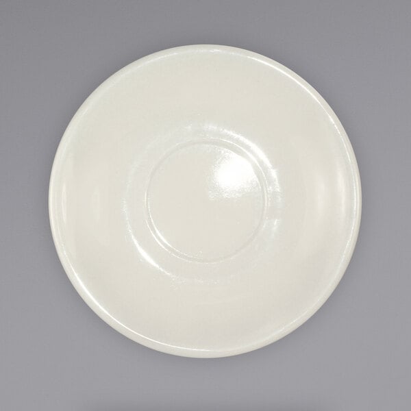 A white plate with a circular design on a gray surface.