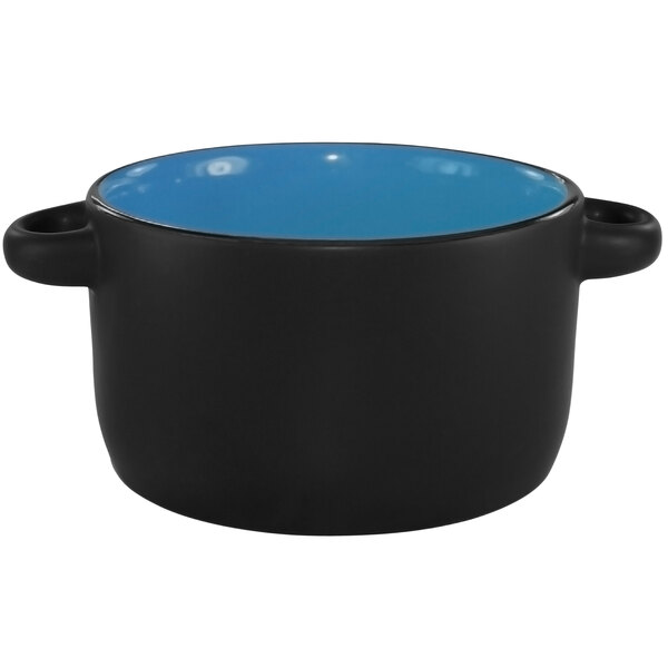 A sky blue stoneware mini casserole dish with black on the inside and handles.