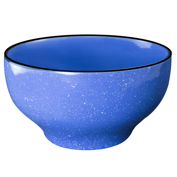 An ocean blue stoneware footed bowl with black specks and a black rim.