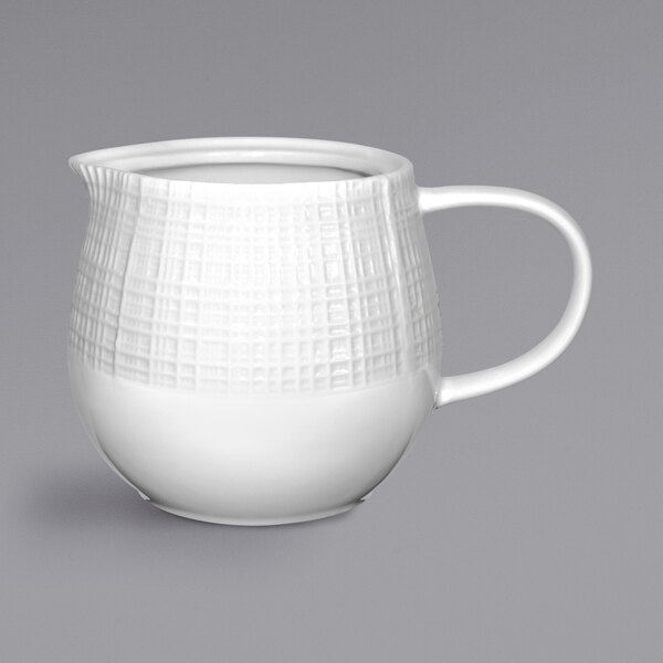 A white porcelain pitcher with a handle.
