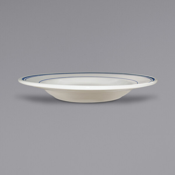 An ivory stoneware pasta bowl with blue bands on the rim.