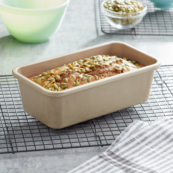 An OXO aluminized steel bread loaf pan with a loaf of bread with seeds on top.