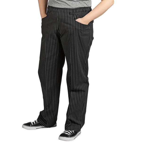 A woman wearing Uncommon Chef pinstripe chef pants with white stripes.