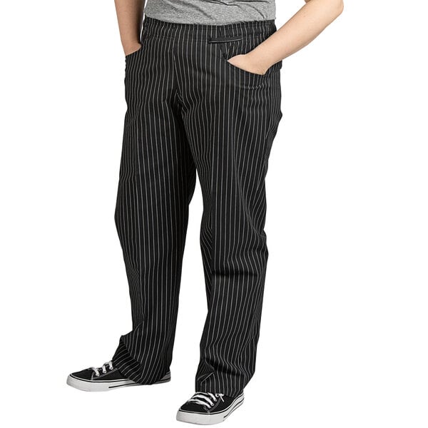 A woman wearing Uncommon Chef pinstripe chef pants.