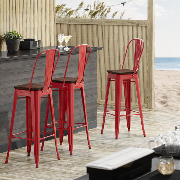 Lancaster Table & Seating Alloy Series Red Metal Indoor Industrial Cafe Bar Height Stool with Vertical Slat Back and Walnut Wood Seat