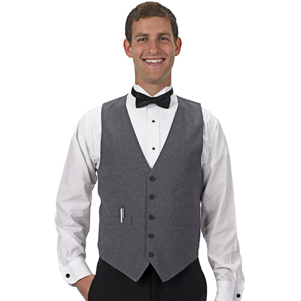 A man wearing a Henry Segal customizable heather gray server vest and bow tie smiles.