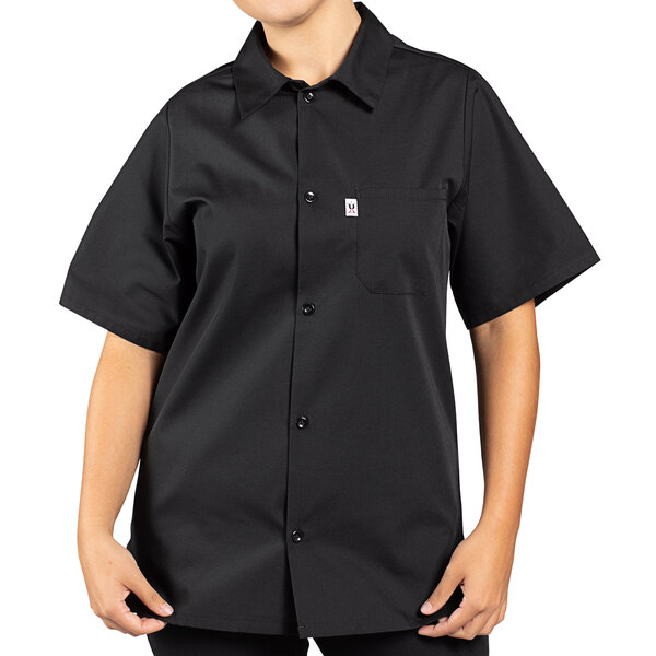 A person wearing a black Uncommon Chef cook shirt with short sleeves.