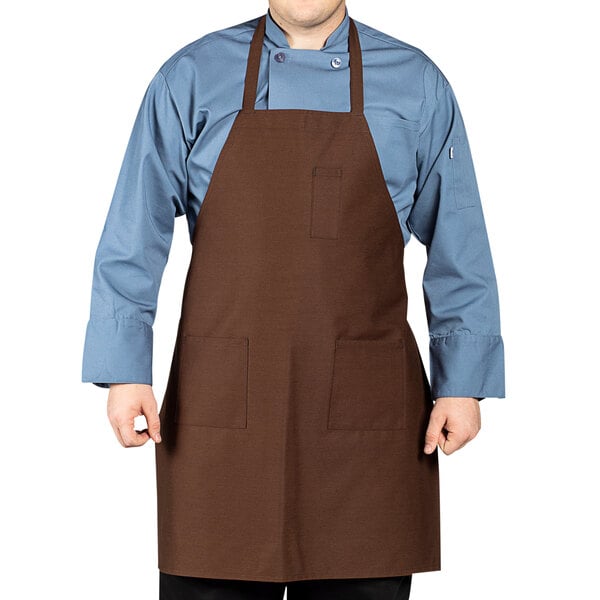 A man wearing a brown Uncommon Chef bib apron with three pockets.