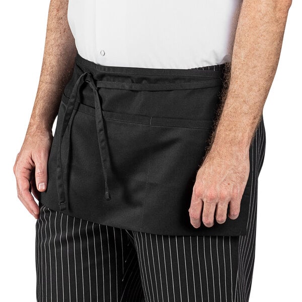 A man wearing a Uncommon Chef black waist apron with three pockets.