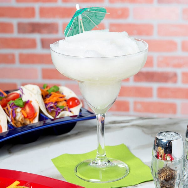 A Carlisle plastic grande margarita glass with a drink in it.