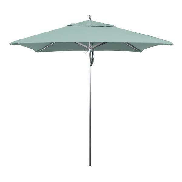 A green California Umbrella on a metal pole.