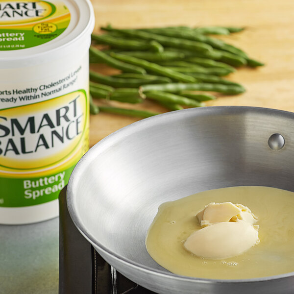A pan with Smart Balance butter in it on a counter next to green beans.