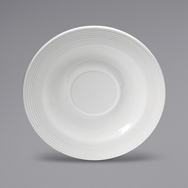 A close-up of a Sant'Andrea Impressions bright white porcelain saucer with a circular pattern on the rim.