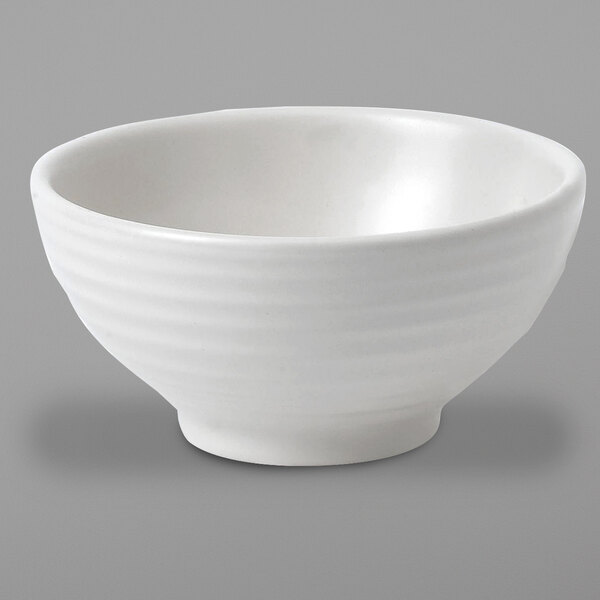 A white bowl with a curved edge on a gray background.