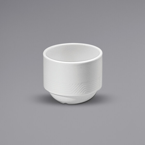 A Sant'Andrea Impressions white porcelain bouillon cup with an embossed rim on a gray surface.