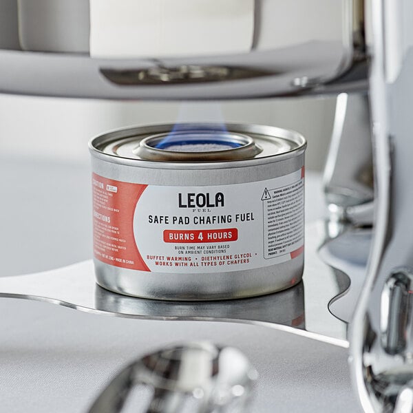A can of Leola chafing dish fuel with a safe pad on a table in a fine dining restaurant.