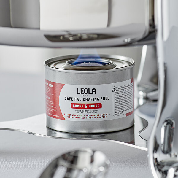 A Leola chafing dish fuel can on a metal tray with a lit wick.