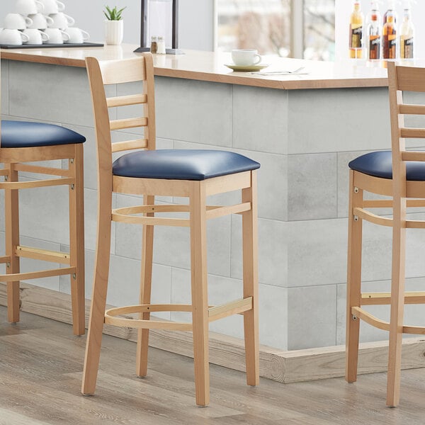 Lancaster Table & Seating Natural Ladder Back Bar Height Chair with 2 1/2" Navy Padded Seat