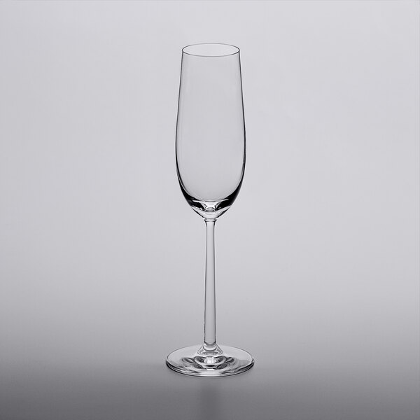 A close up of a Lucaris Soul champagne flute on a gray surface with a white background.