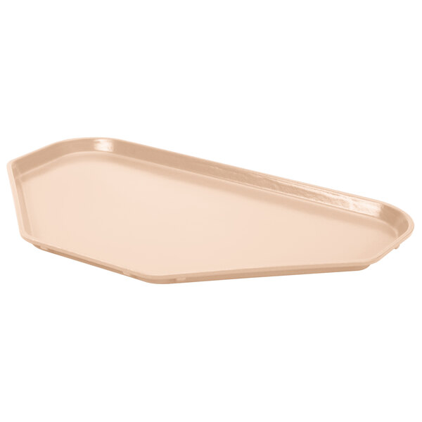 A peach fiberglass trapezoid tray with a white surface.