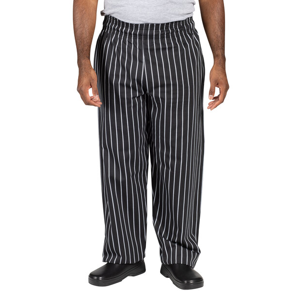 A person wearing Uncommon Chef black and white striped chef pants.