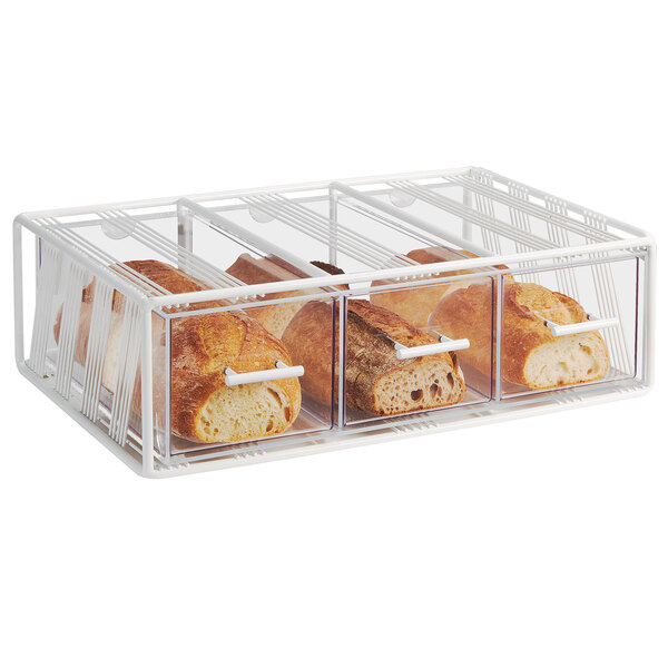 A white Cal-Mil bread display case with three drawers holding bread.
