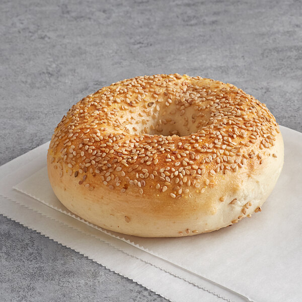 An Original New York Style Sesame Seed Bagel with sesame seeds on top of a napkin.