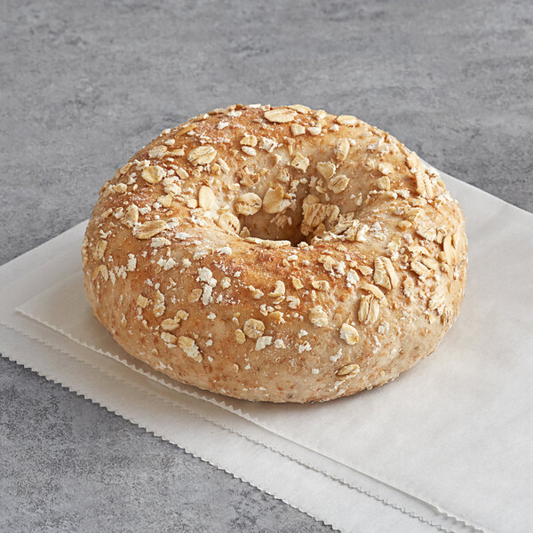 An Original Bagel New York wheat bran bagel with oats on a napkin.