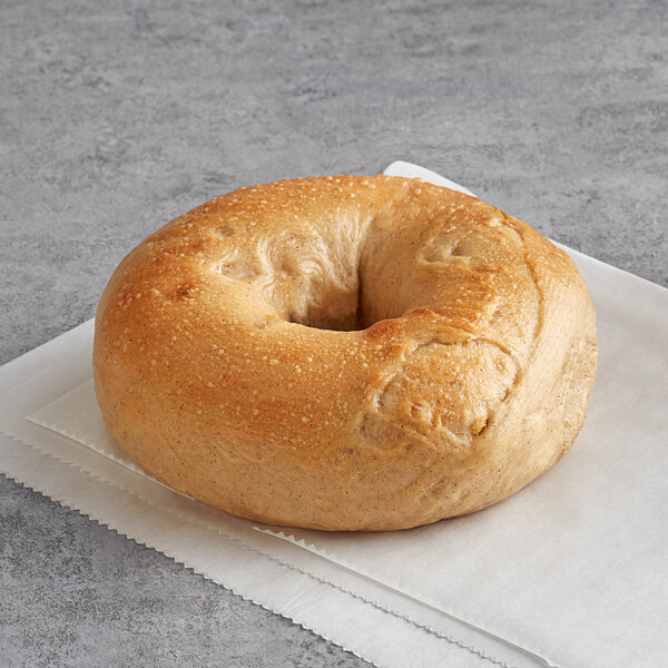 An Original New York Style Apple Cinnamon Bagel with a hole in the middle on a napkin.