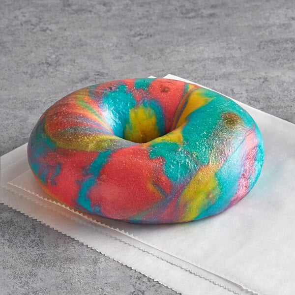 An Original Bagel New York Style Rainbow Bagel with a tie dye design on a white surface.