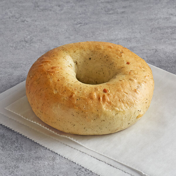 An Original New York Style Spinach Bagel with a hole in the middle on a napkin.