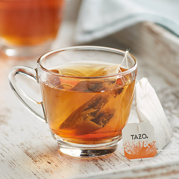 A glass cup of Tazo Organic Chai tea with a tea bag in it.